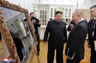 North Korea’s leader Kim Jong Un (C) presents a gift to Russia’s president Vladimir Putin (front R) at the Kumsusan State Guesthouse in Pyongyang
